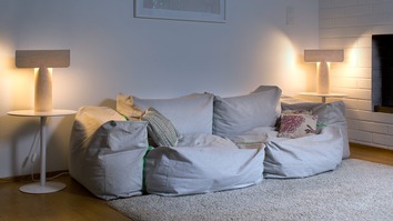 Teelo 8020 Bordslampa Naturbjörk på sidobord bredvid en bulkig soffa