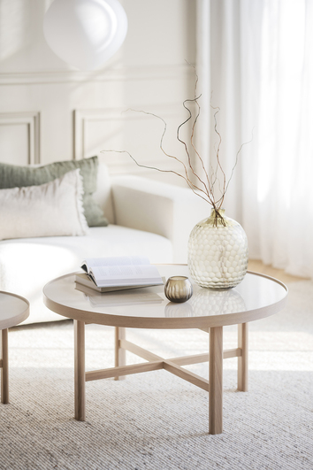 Marsden Soffbord Keramik / Vitpigmenterad Ek med dekorativa detaljer framför soffa i beige tyg