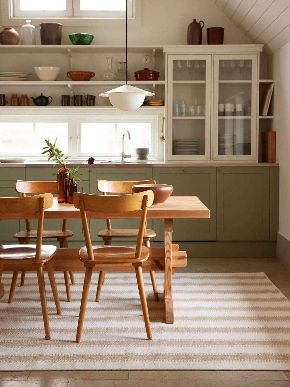 Ett lantligt och personligt kök med Classic Collctions matta Stripes liggandes under köksbordet.